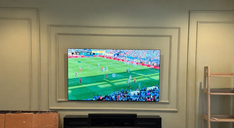 Finished 77-inch LG OLED television mounted level on a decorative living-room wall